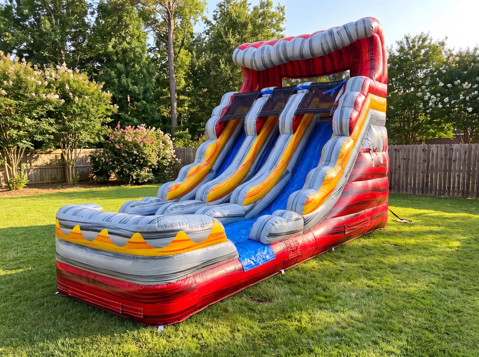 16 ft Volcano Double Lane Slide set up in a grassy backyard, in red, gray and yellow